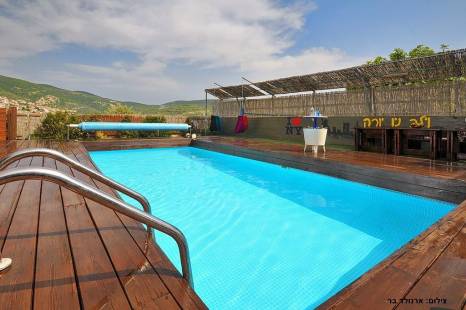 חצר גדולה עם מתחם דק ובריכת שחייה